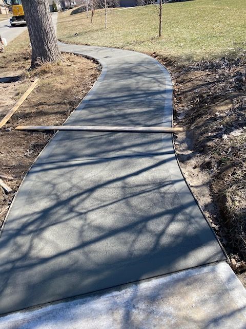 A concrete walkway is being built in a park.