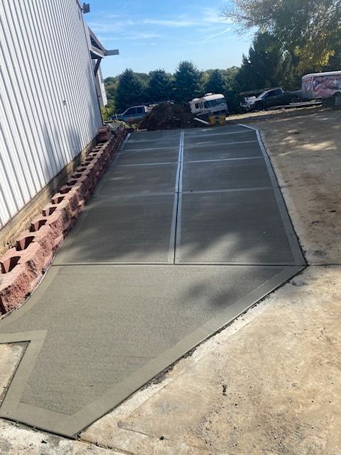 A concrete driveway is being built in front of a house.