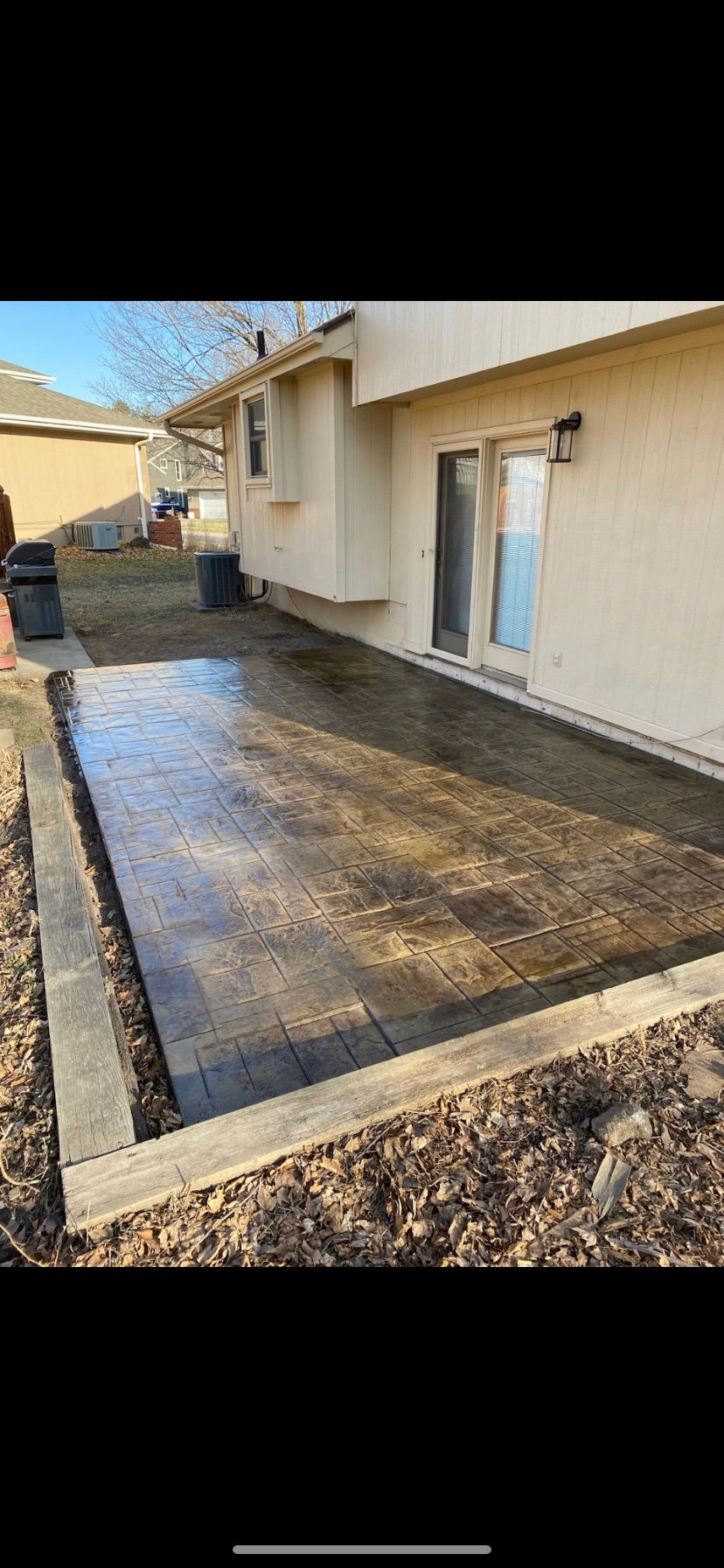 A concrete patio is being built in front of a house.