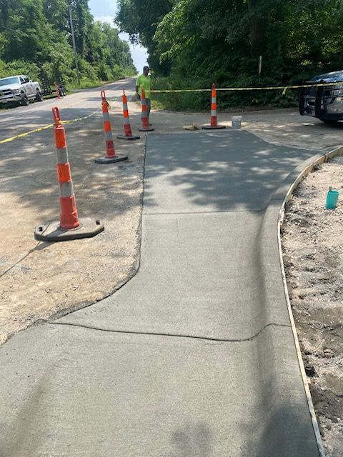 A concrete sidewalk is being built next to a road.