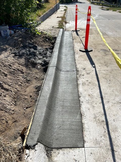 A concrete curb is being built on the side of the road