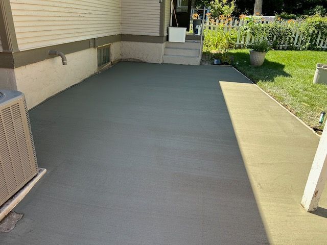 A concrete driveway is being built in front of a house.