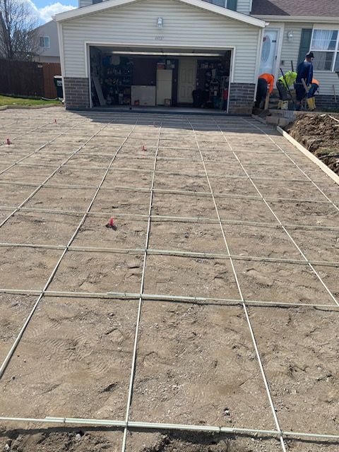 A concrete driveway is being built in front of a house.