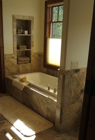 A bathroom with a bathtub and a window