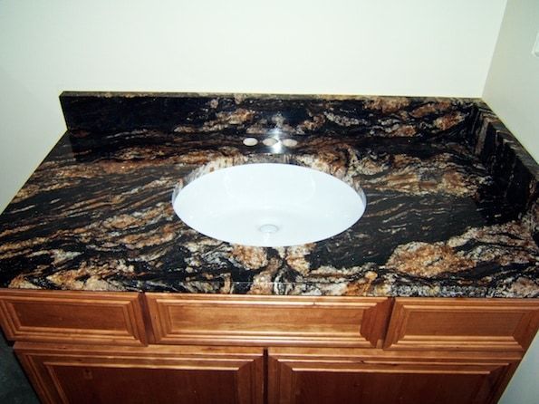A bathroom sink with a black granite counter top