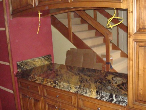 A kitchen counter with a staircase in the background