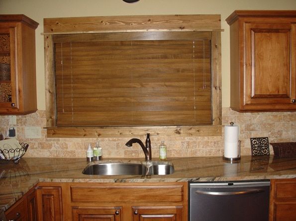 A kitchen with a sink and a window with blinds