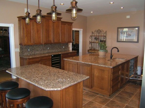 A kitchen with granite counter tops and wooden cabinets