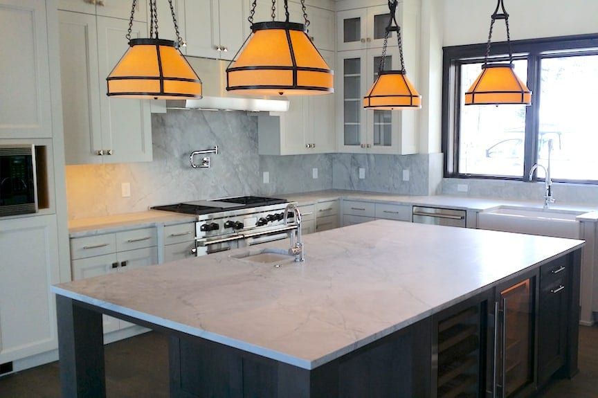 A kitchen with a large island and a stove top oven