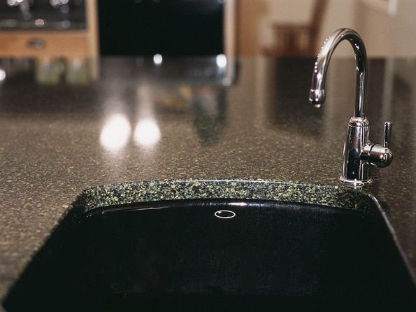 A black sink with a chrome faucet on a kitchen counter.