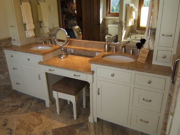 A bathroom with two sinks a mirror and a stool