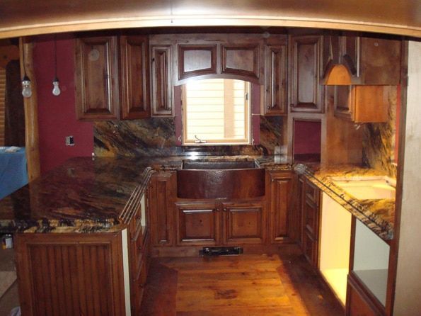 A kitchen with wooden cabinets and a copper sink