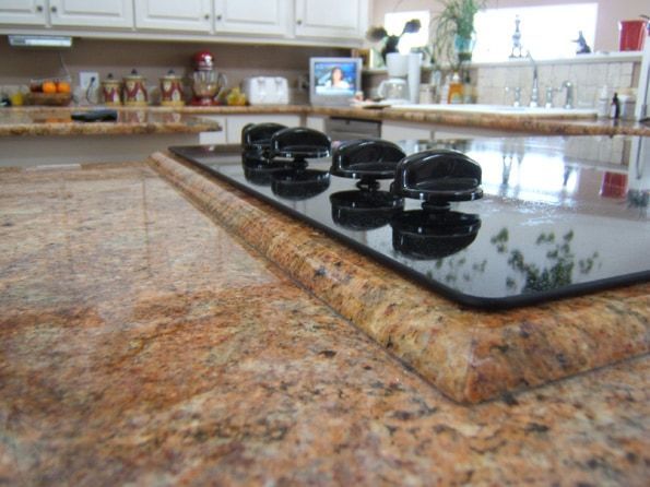 A kitchen with granite counter tops and a stove top oven