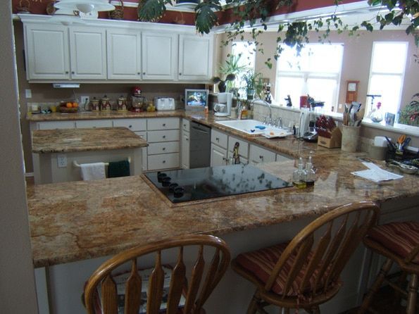 A kitchen with granite counter tops and white cabinets