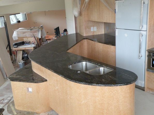 A kitchen with two sinks and a refrigerator