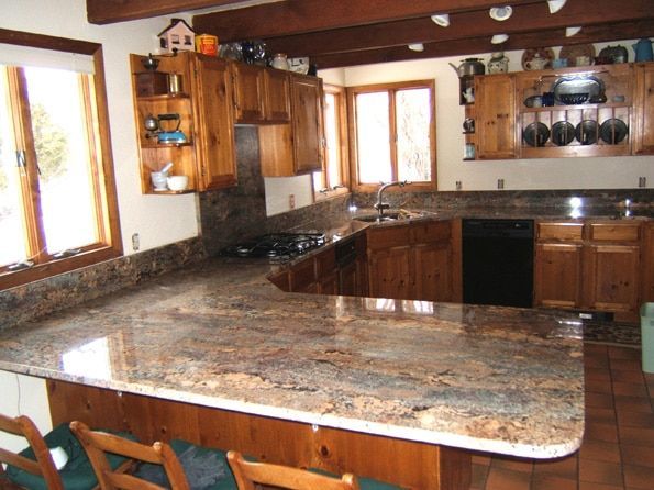 A kitchen with granite counter tops and wooden cabinets