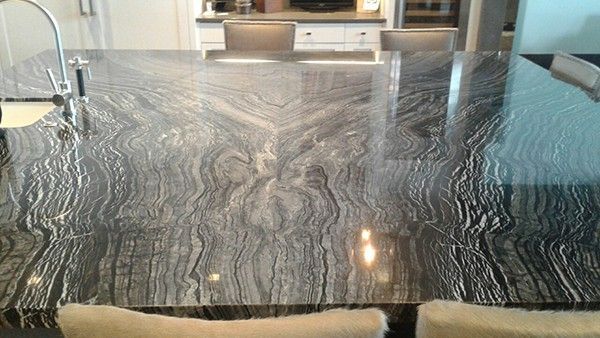 A kitchen with a large granite counter top and a sink.