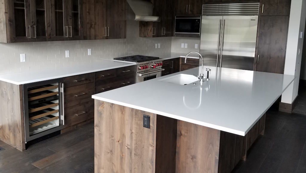 A kitchen with wooden cabinets and white counter tops