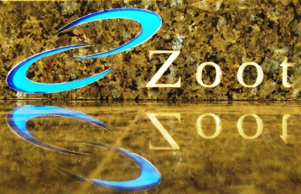 A zoot logo is reflected in the water