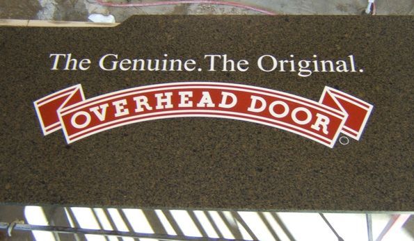 An overhead door sign that says the genuine the original