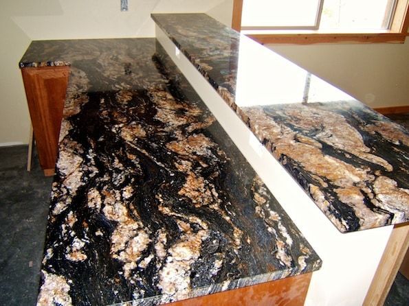 A kitchen counter with a black and brown granite counter top