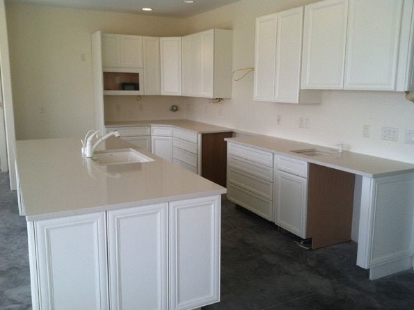 A kitchen with white cabinets and granite counter tops