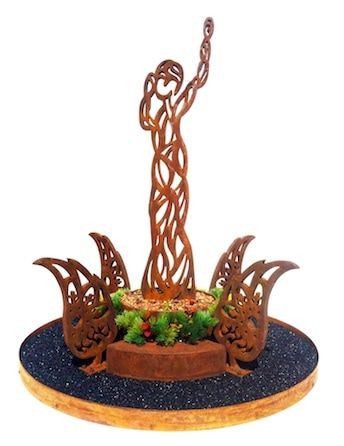 A statue of a woman is surrounded by flowers