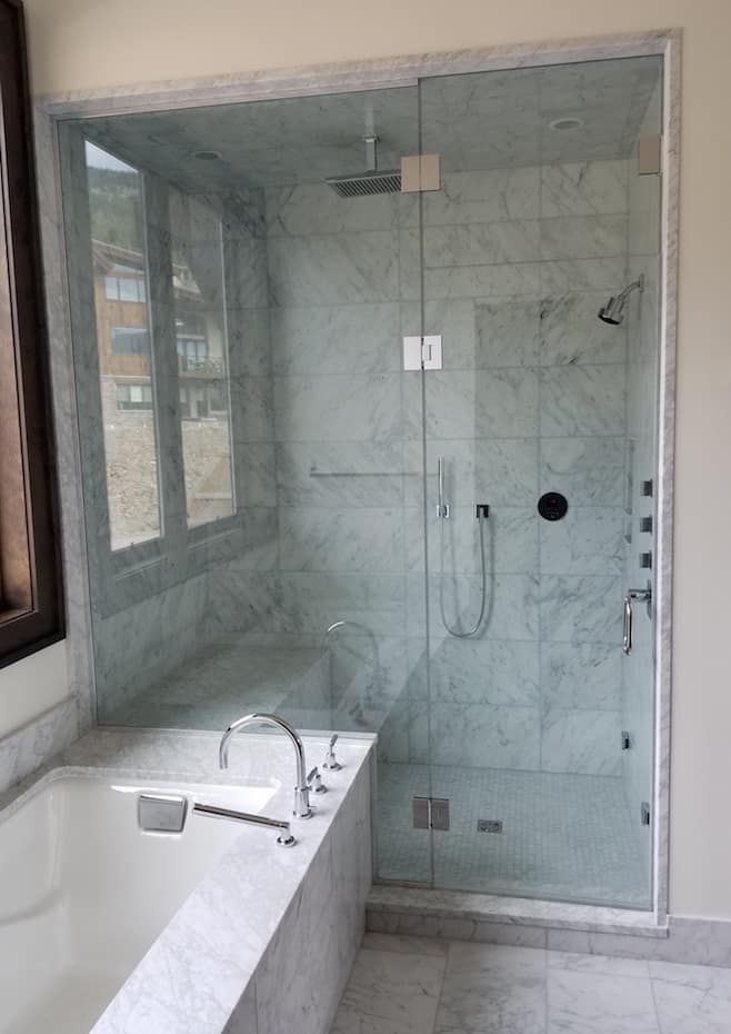 A bathroom with a walk in shower and a bathtub.