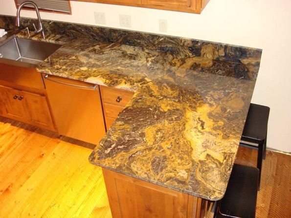 A kitchen with a sink , dishwasher , and granite counter tops.