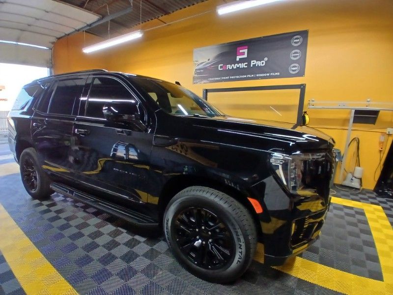 A black suv is parked in front of a sign that says carpac pro