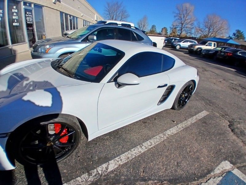 A white sports car is parked in a parking lot