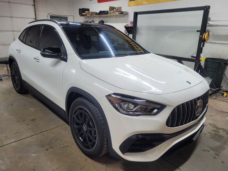 A white mercedes benz gla 45 amg is parked in a garage.