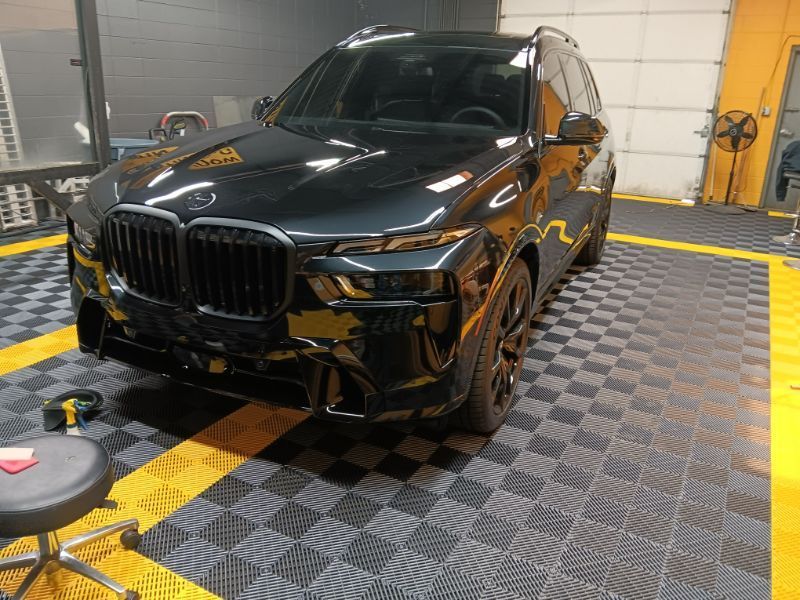 A black bmw x5 is parked in a garage.