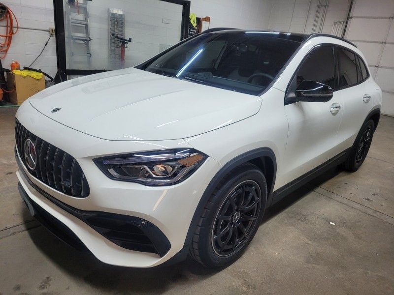 A white mercedes benz gla 45 amg is parked in a garage.