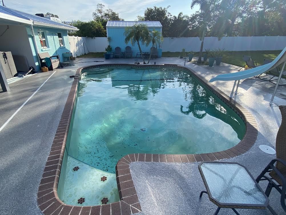 A large swimming pool with a slide in the backyard