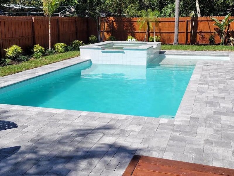 A large swimming pool with a wooden fence in the background