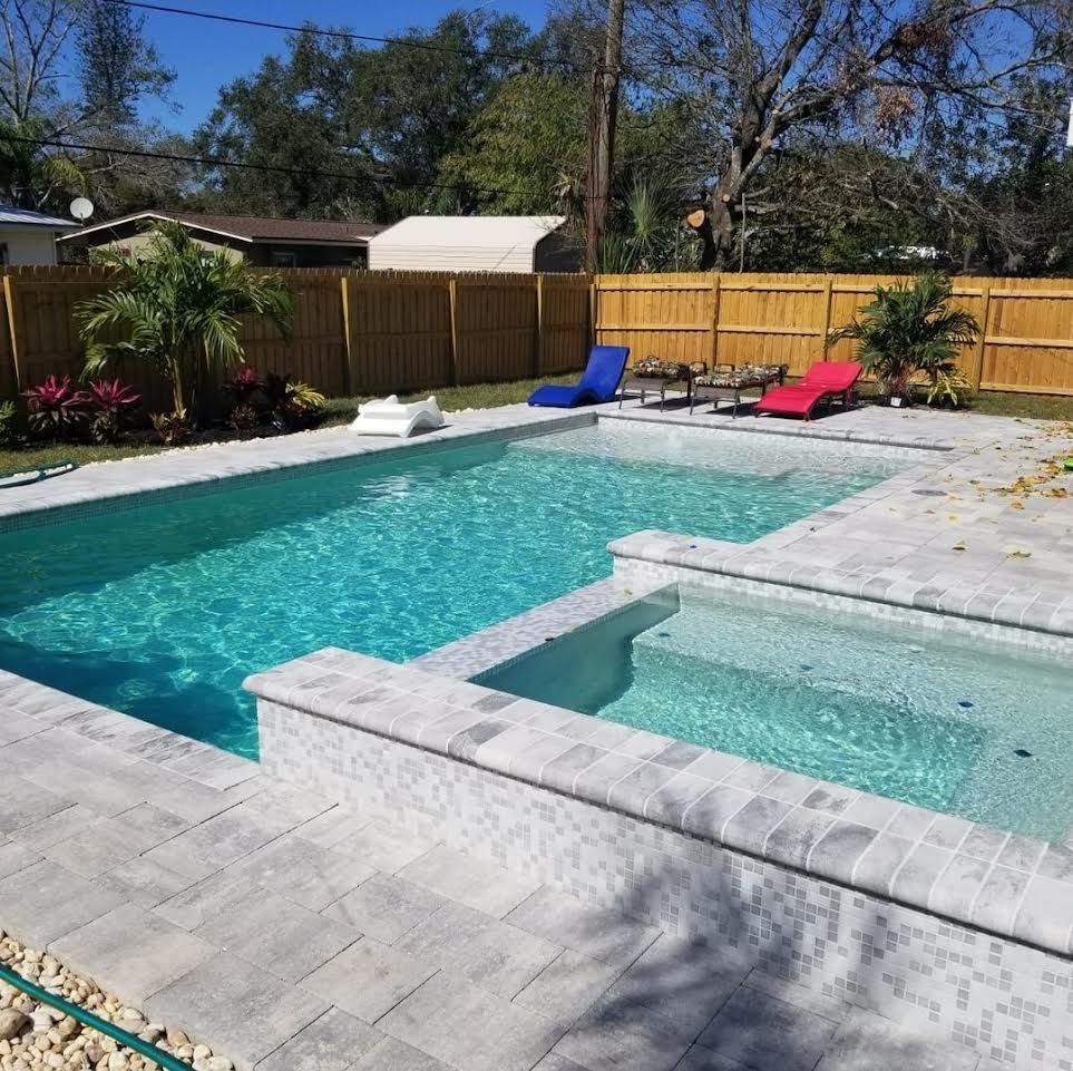 A large swimming pool with a hot tub in the middle
