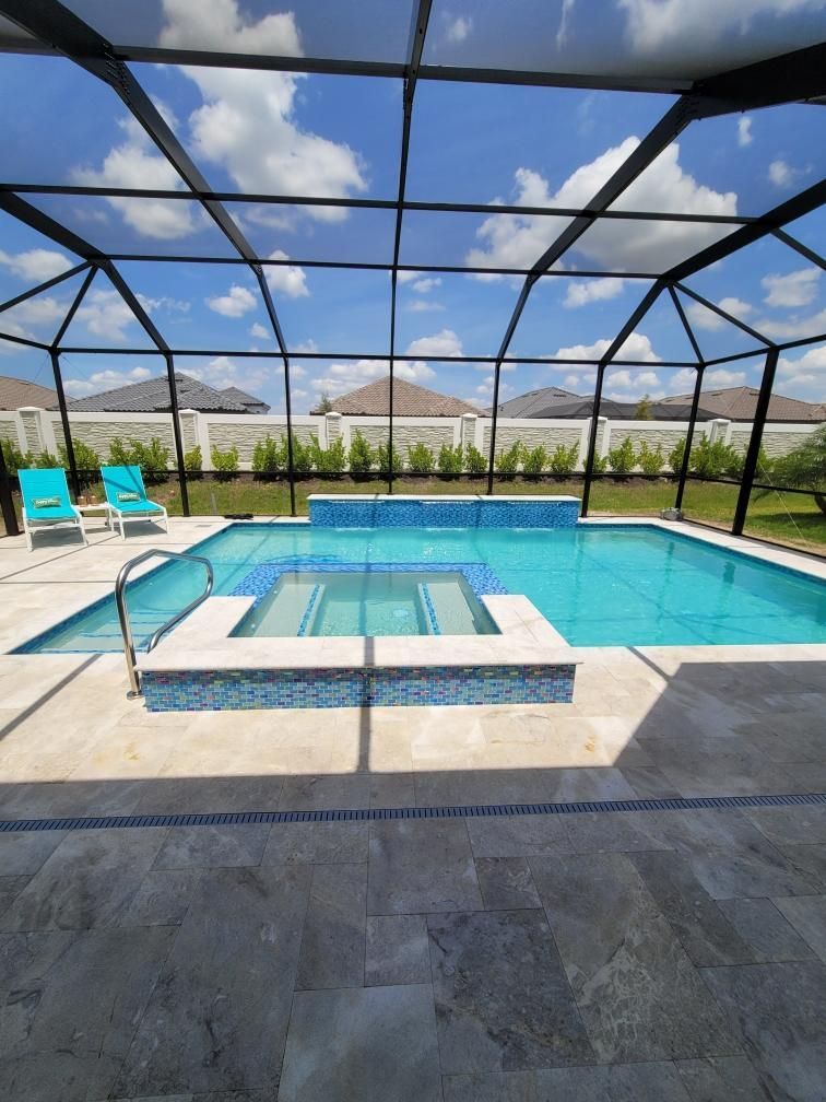 A large swimming pool with a screened in area and chairs around it