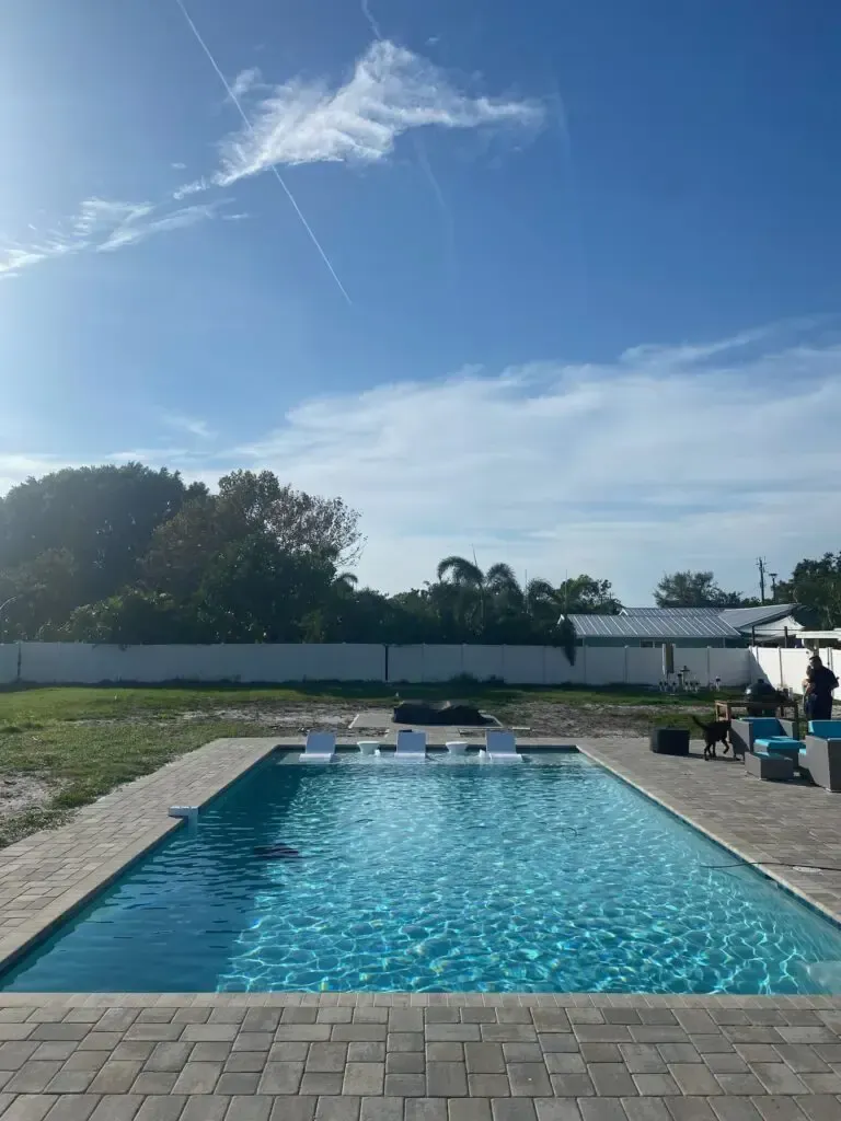 A backyard with a swimming pool and a fence surrounding it