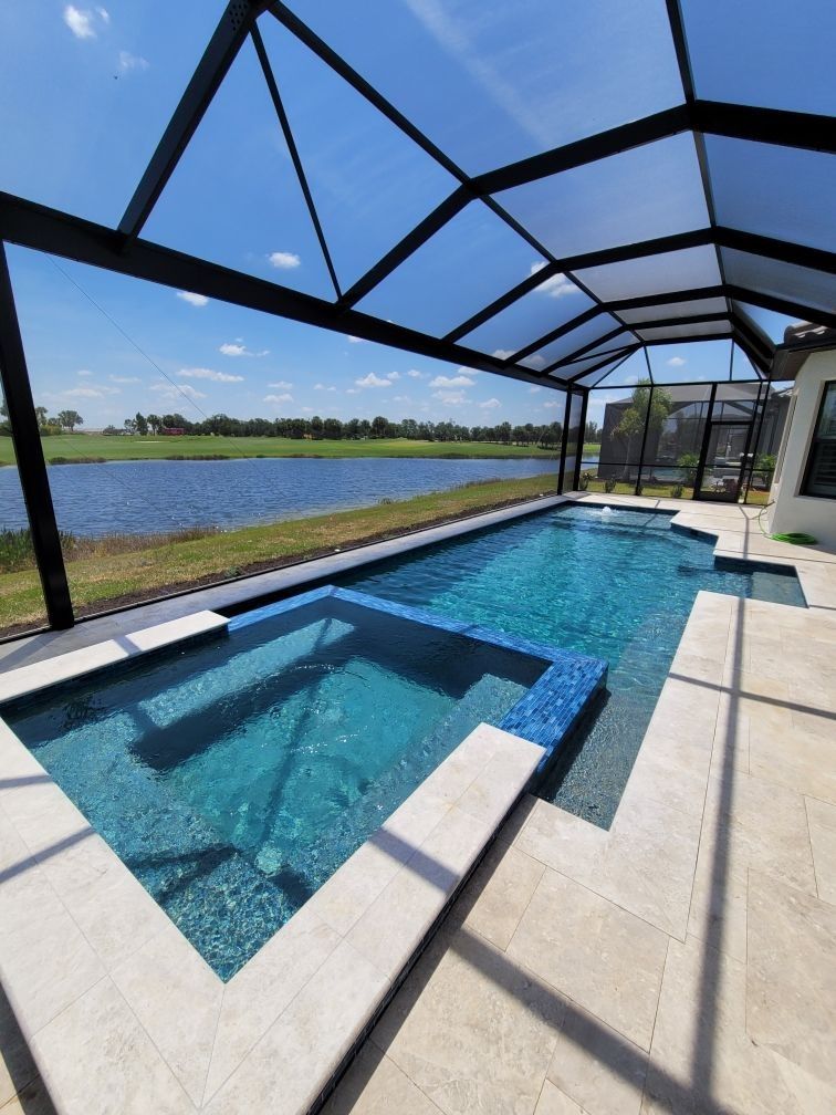 A large swimming pool with a canopy over it and a view of a lake.