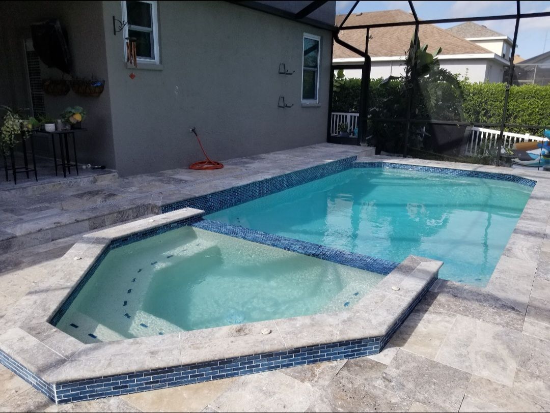 A large swimming pool with a jacuzzi next to it