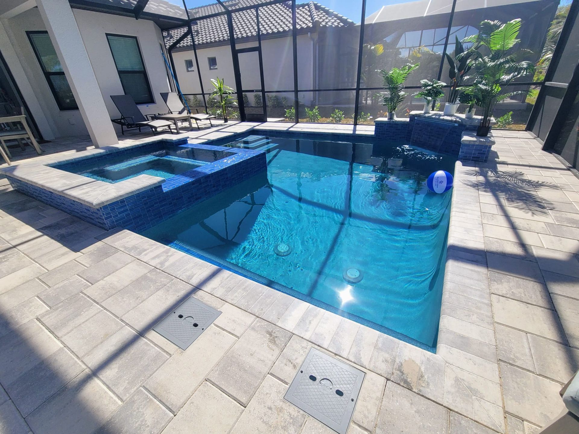 Lanser - A large swimming pool with a screened in area and a sunset in the background.