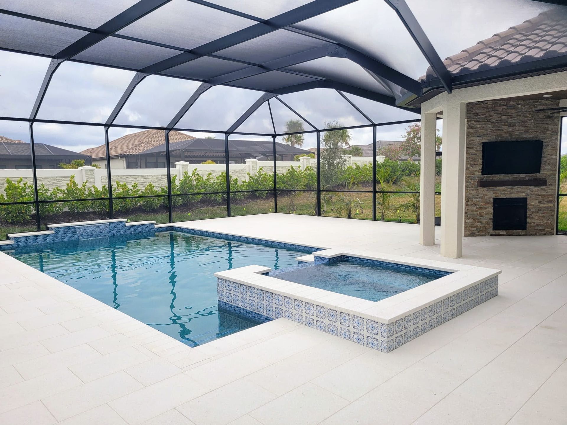 Rubin - A large swimming pool is surrounded by a screened-in area.