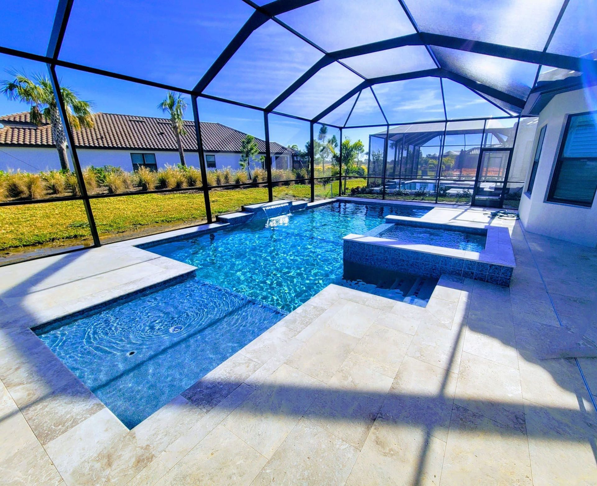 Gambardella - A large swimming pool is surrounded by a screened-in area.