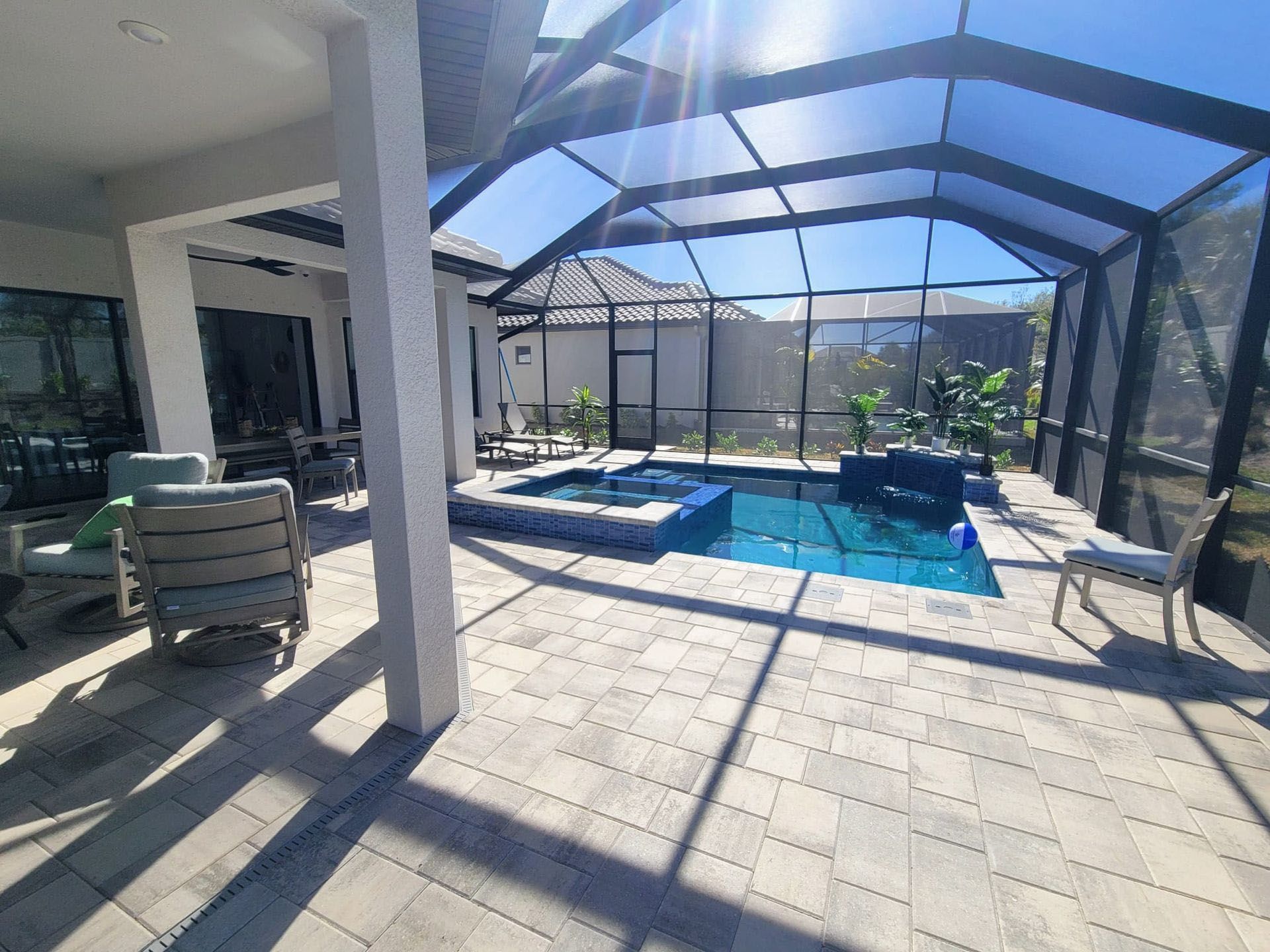 Daryl - A large swimming pool with a hot tub in the backyard of a house.