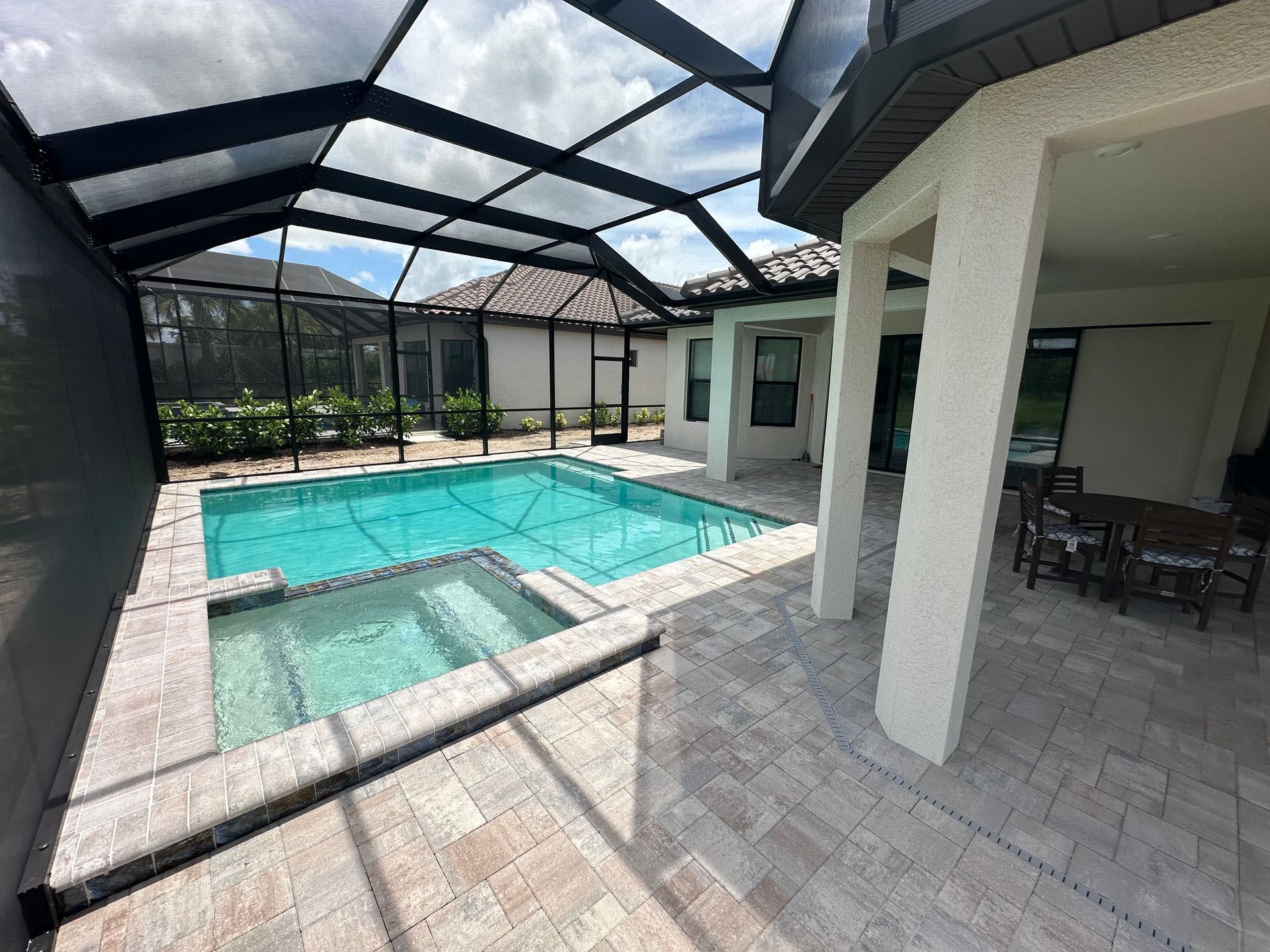 There is a large swimming pool in the backyard of a house.