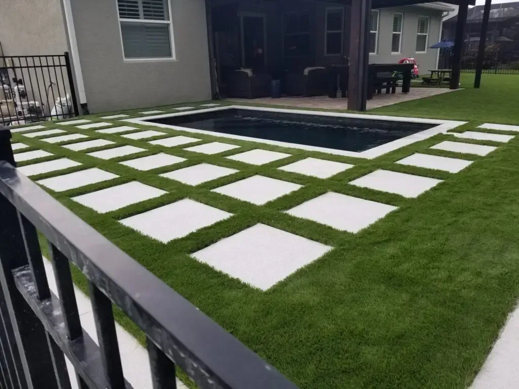 A backyard with a swimming pool and a fence surrounding it