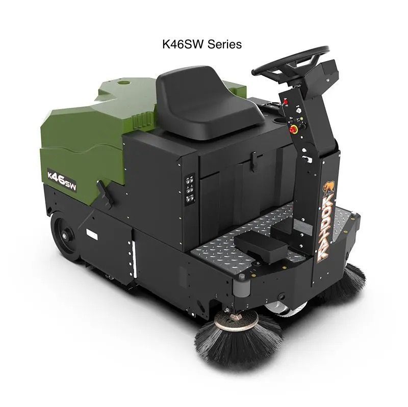 A green and black sweeper is sitting on a white surface.