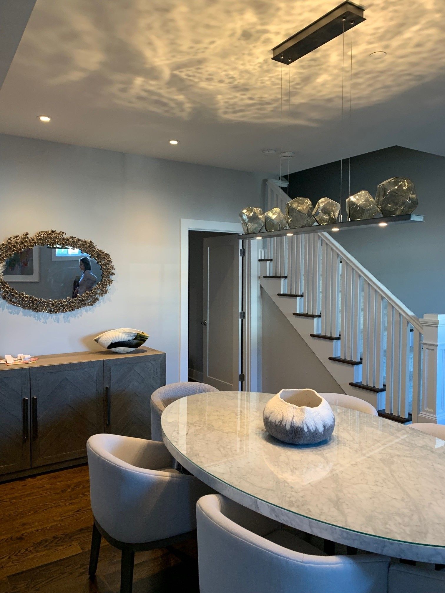 A dining room with a round table and chairs.