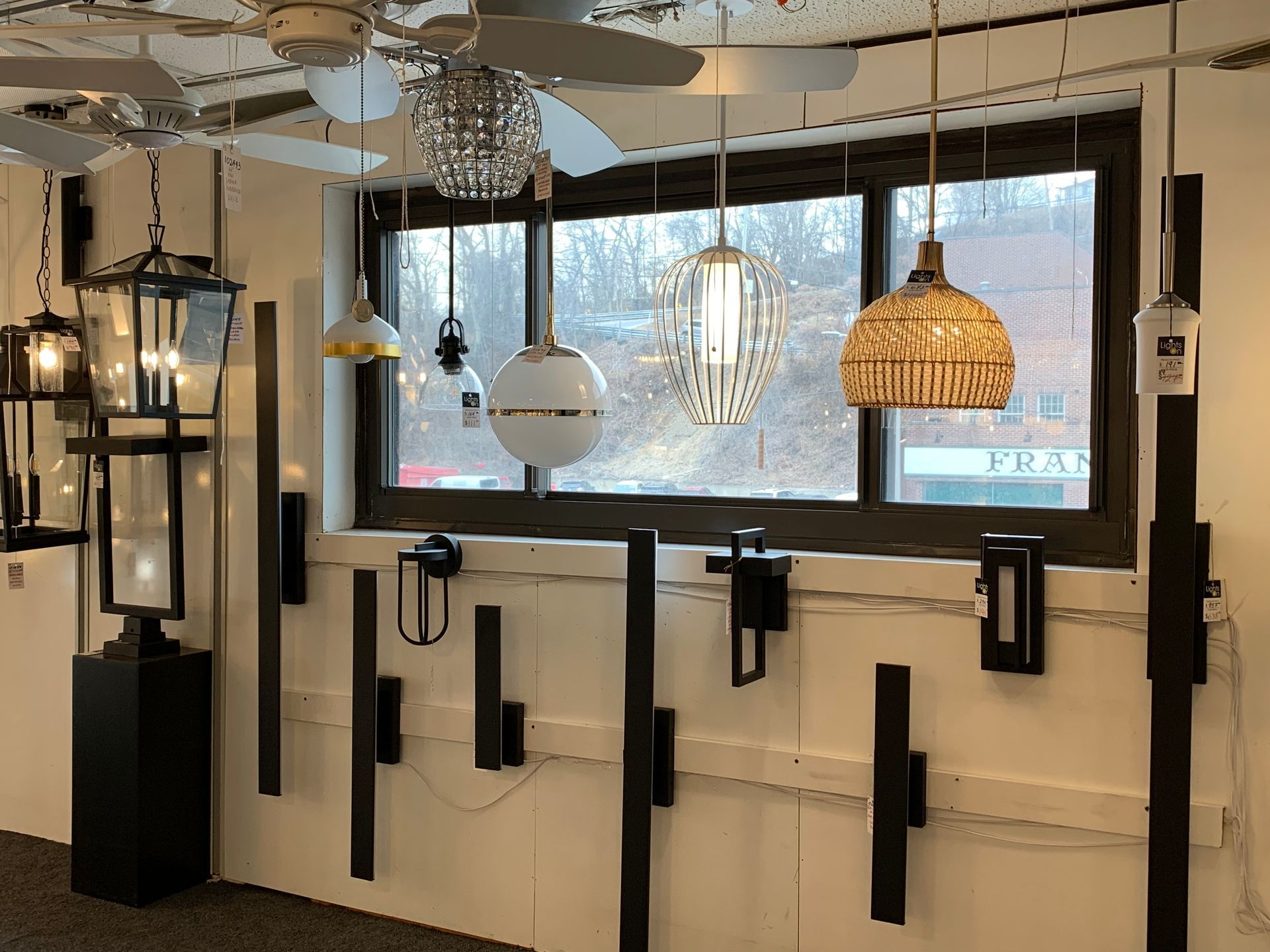 A room with a lot of lights hanging from the ceiling and a window.